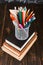 Books and stand for pens on a wooden table. Teacher's day concept and back to school