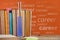 Books on the table against orange blackboard with career text