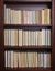 Bookshelf with books displayed backwards