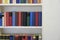 Bookshelf with colorful books in white wall