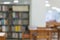 Bookshelf and table desk in library, education abstract blur