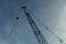 The boom of a crane against a blue sky.