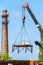 Boom of crane on background of brick chimney boiler