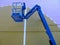Boom lift. Blue elevated work bucket platform, articulating bending arm