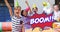 Boom text on speech bubble against kids wearing party hats in a birthday party