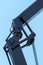 Boom of a tower crane in close-up against the blue sky. A working crane on a construction site. View of the crane hook, cables and