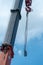 Boom of a tower crane in close-up against the blue sky. A working crane on a construction site. View of the crane hook, cables and
