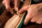 Bootmaker sitting in workshop making shoes