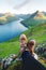 Boots of lonely tourist over majestic fjords of Funningur