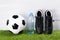 Boots, soccer ball, a bottle of water, stand on the grass, on a gray background, for the bench