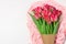 Boquet of red and pink tulips on the light pink cloth. Floral white background with space for text