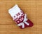 Bordeaux and white socks with a festive bow, isolated on a wooden background.