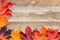 Border of autumn maple leaves on wooden background - a beautiful template for an autumn card or congratulations