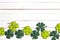 Border of felt four-leaf clover on white wooden background. Luck