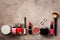 A border of female decorative cosmetics make-up on a dark brown rustic background. Top view, flat lay, copy space