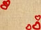 Border frame of red hearts on sack canvas burlap