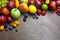 Border of mixed fruits with water drops on wooden texture