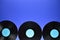 Border of old black vinyl records on blue background