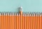 Border of orange sharpened pencils, with one eraser in the middle