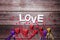 Border from red, violet and gold decorative hearts and word love on vintage wooden background