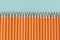 Border of sharpened orange pencils, with copy space.