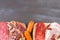 Bordure of different Spanish appetizer, like fuet, jamon, chorizo, bacon and lomo embuchado on black wooden background.