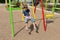 A bored boy sits on a swing in the courtyard of a residential building