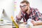 Bored exhausted man sitting on workplace and looking at monitor