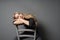 Bored female sitting astride on chair and staring at ceiling