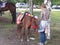 Bored girl standing with baby horse outdoor