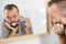 Bored guy brushing his teeth in bathroom