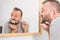 Bored guy brushing his teeth in bathroom