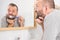 Bored guy brushing his teeth in bathroom