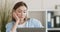 Bored lazy woman sitting at desk and working with laptop