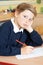 Bored Male Elementary School Pupil At Desk