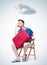 Bored man in summer clothes with a red suitcase sitting on a chair waiting. Over the head of a cloud