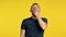 Bored man yawns on yellow background