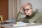 Bored teen girl sitting at home with book, doing homework