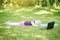 Bored tired girl child sleeping while doing sport workout outdoor online. Video yoga class on Internet. Funny sleeping kid