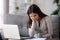 Bored unmotivated woman sitting at table with laptop and documents