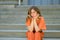 Bored woman sitting waiting on steps with thoughtful expression