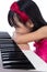 Boring Asian Chinese little girl playing electric piano keyboard