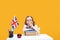 Boring caucasian schoolgirl sits at the desk with stack of books. English lesson. Great Britain flag