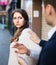 Boring male person accosting to female at crowded street