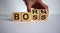Born to be a boss. Man hand flips wooden cubes with words `born boss`. Business concept, beautiful white background, copy space