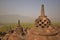 Borobudur Giant Stupas during late sunrise with misty feeling among the forest in the background