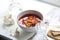 Borsch submitted with sour cream and garlic and a vodka wine-gla