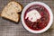 Borscht - sour soup common in Eastern Europe - made with red beetroots and sour cream - piece of bread