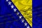 Bosnia and herzegovina flag development, fence mesh and barbed wire. Emigrants isolation concept. With place for your text