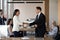 Boss shaking hand of asian employee congratulating worker with promotion